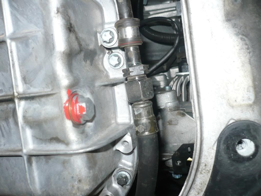 Where is the engine oil drain plug located on a car?